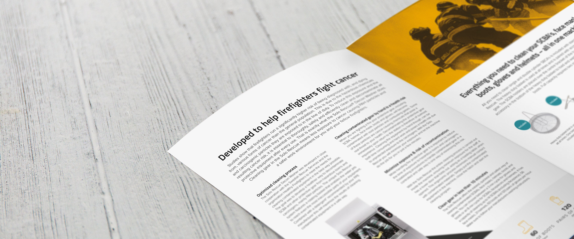 Offenes Magazin auf hellem Holzuntergrund mit Artikel mit dem Titel „Entwickelt, um Feuerwehrleute im Kampf gegen Krebs zu unterstützen“ und Bildern von Feuerwehrleuten.