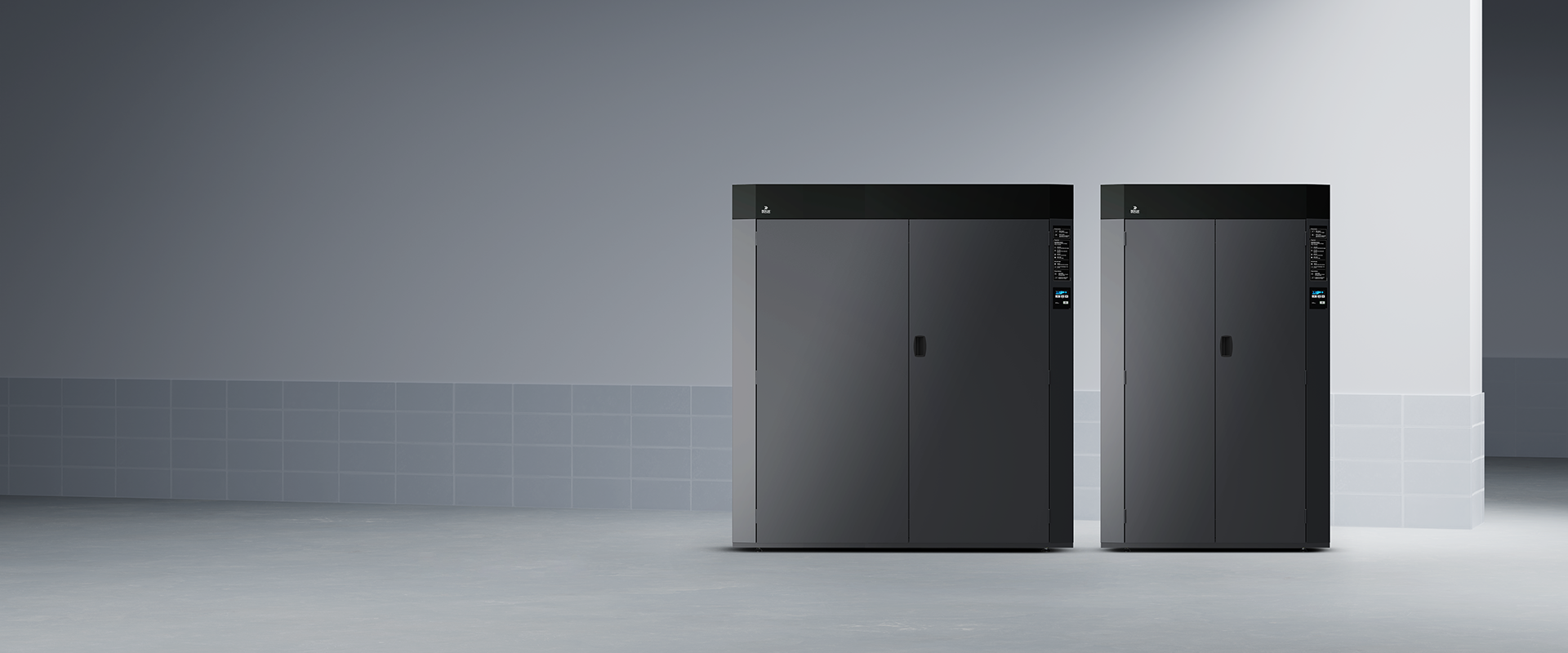 Two dark drying cabinets side by side in tiled room; both feature top control panels and sleek industrial design.