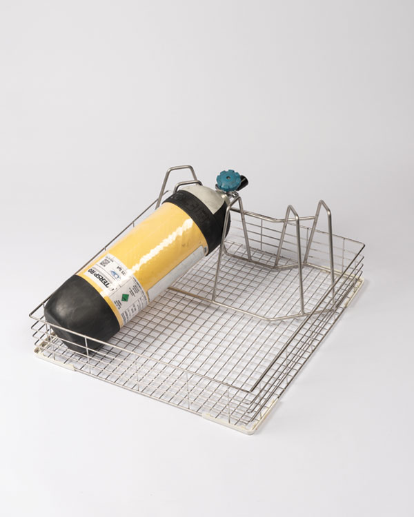 Halterung für Pressluftatmer und Helm für den Decon Washer Pro S mit einem gelben Interspiro-Atemgerät, gesichert in einem Drahtgestell aus Metall.