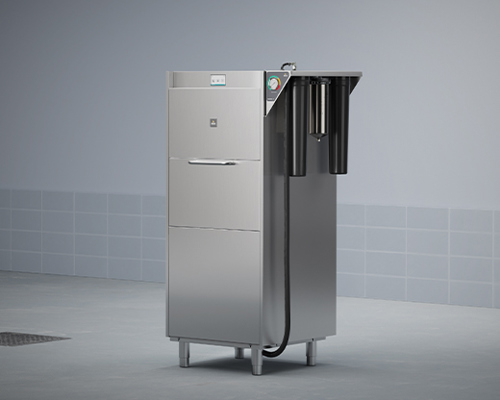 Metallic gear washer in tiled room with three cylindrical filters on right side and control panel on front.