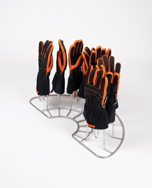 Metallhalter für Ausrüstung mit schwarzen und orangefarbenen Handschuhen aufrecht positioniert zur Dekontamination.